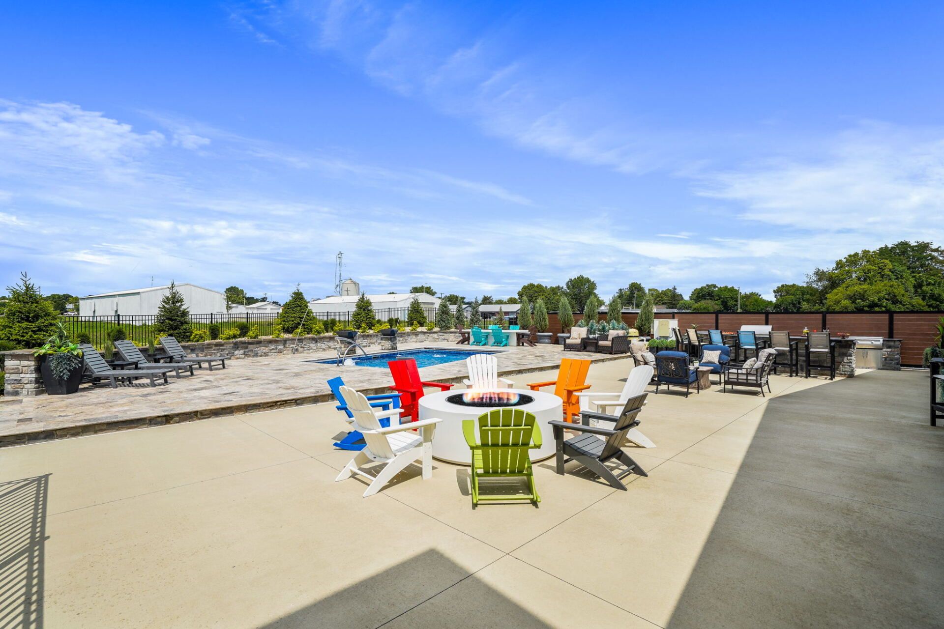 Colorful chairs on a rooftop patio with tables, lounge seating, and a clear blue sky.