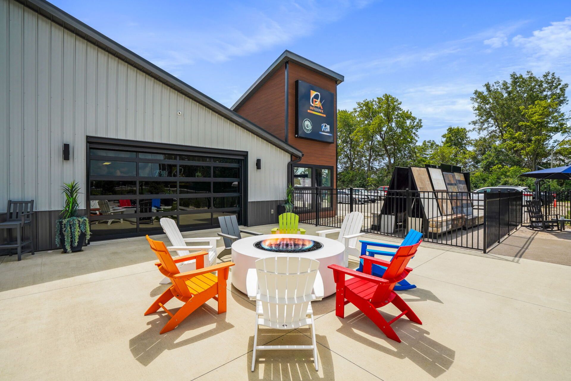 Outdoor patio with colorful Adirondack chairs around a fire pit beside a modern building