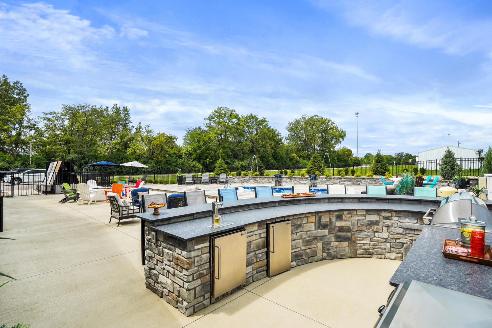 Outdoor resort pool with stone bar, lounge chairs, and blue sky
