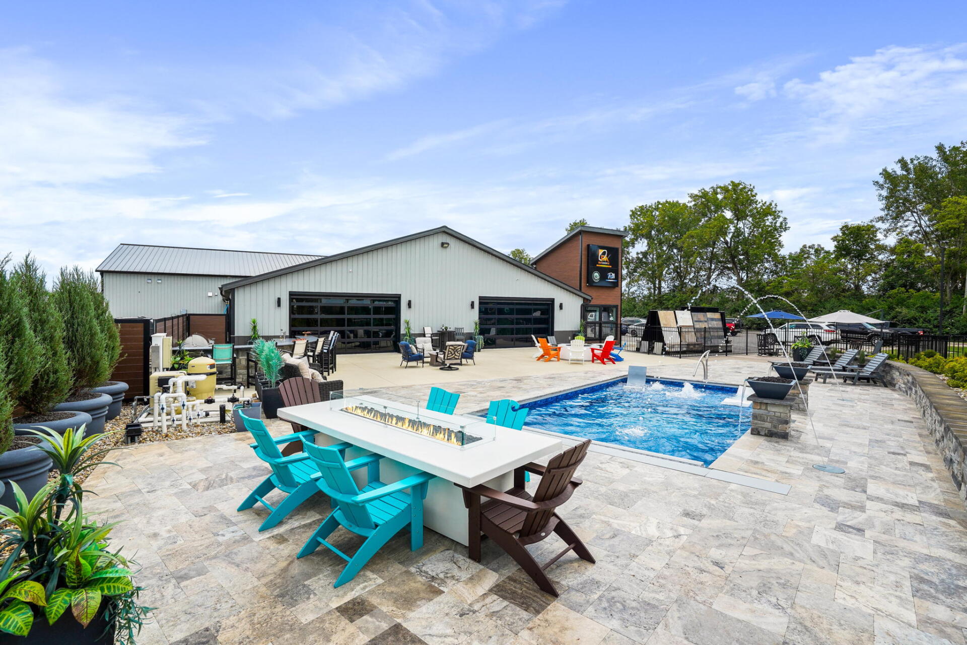 Outdoor patio with turquoise chairs and tables beside a blue swimming pool and building under a clear sky