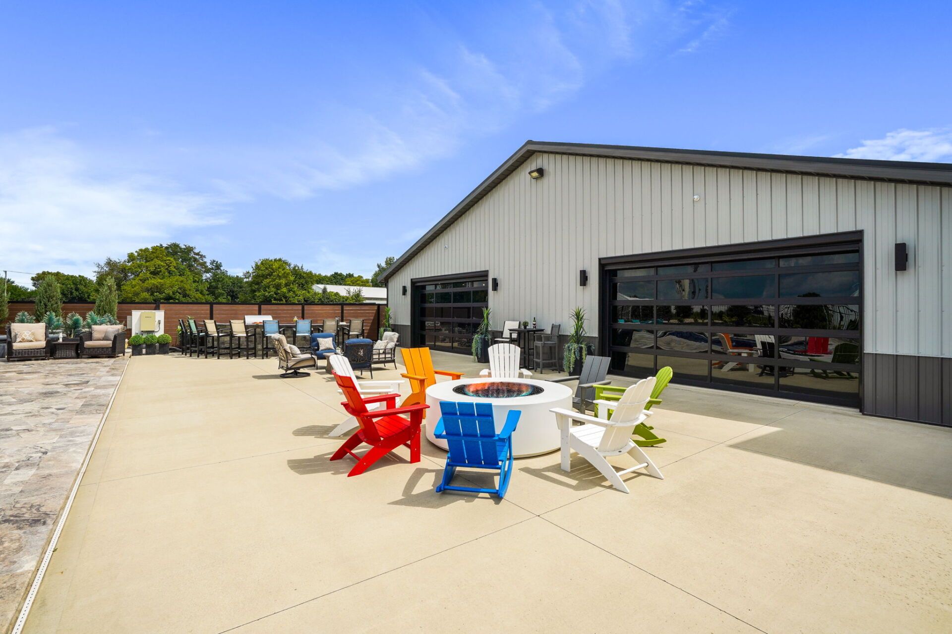 Outdoor patio with colorful chairs beside a modern building under a blue sky