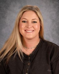 A woman with long blonde hair is smiling for a picture.