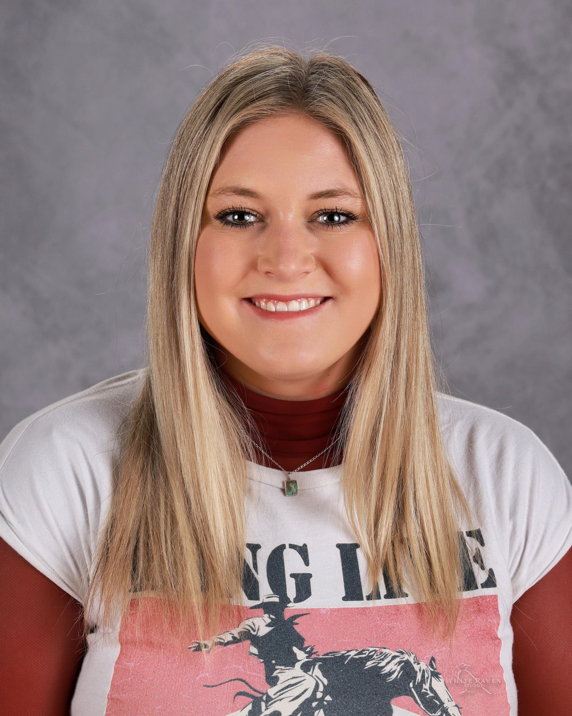 A woman with long blonde hair is smiling for a picture.