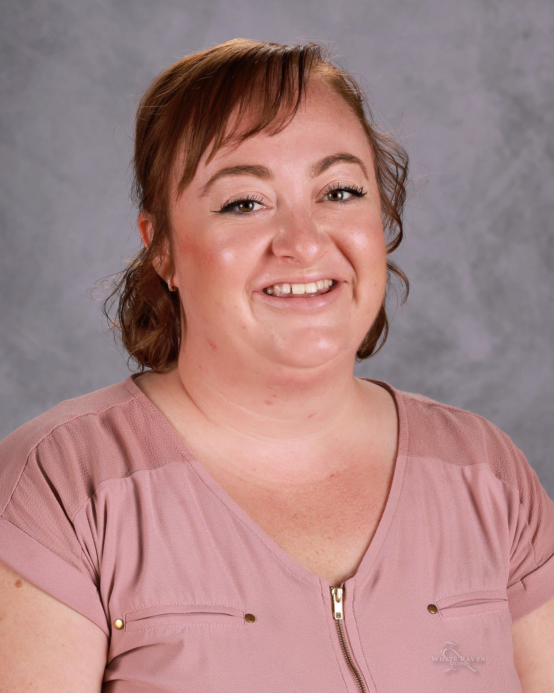 A woman in a plaid shirt is smiling for a picture.