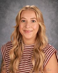 A young woman with blonde hair is smiling for a picture.
