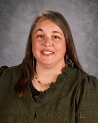 A woman in a black shirt is smiling for a picture.