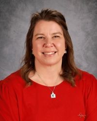 A woman in a white shirt is smiling for the camera.