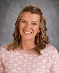 A woman in a striped shirt is smiling for the camera.