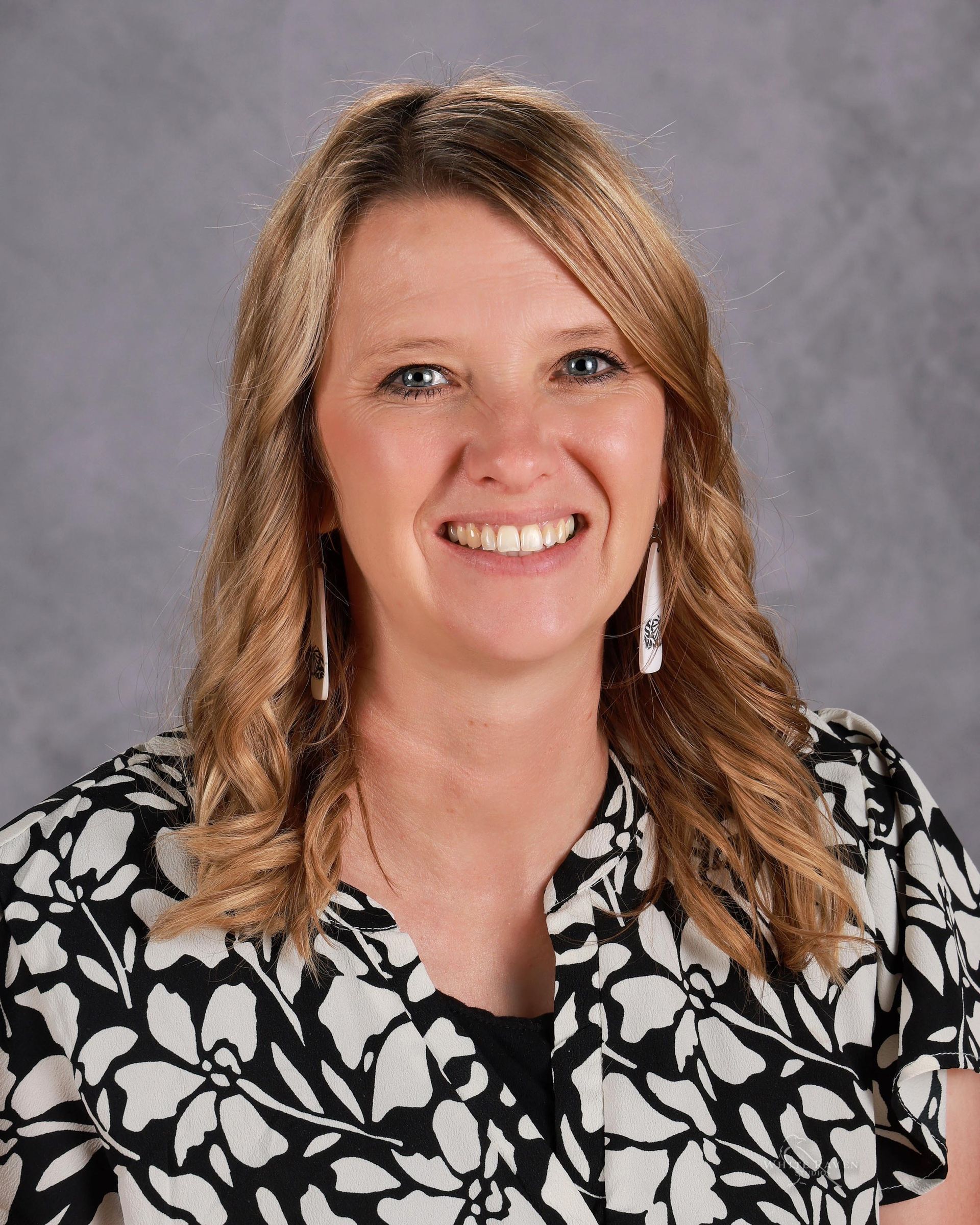 A woman in a striped shirt is smiling for the camera.
