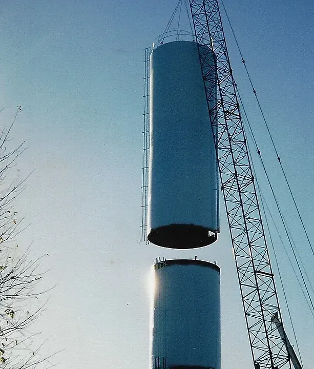 two blue cylinders are being lifted by a crane