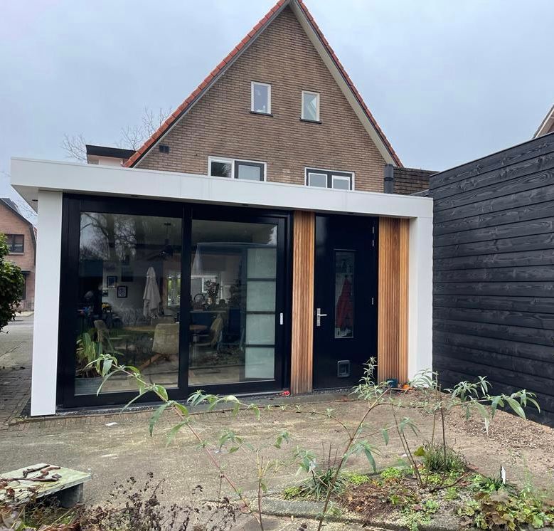 Moderne aanbouw glas hout. Schuifdeuren terras detail. Verbouwing interieur woning.