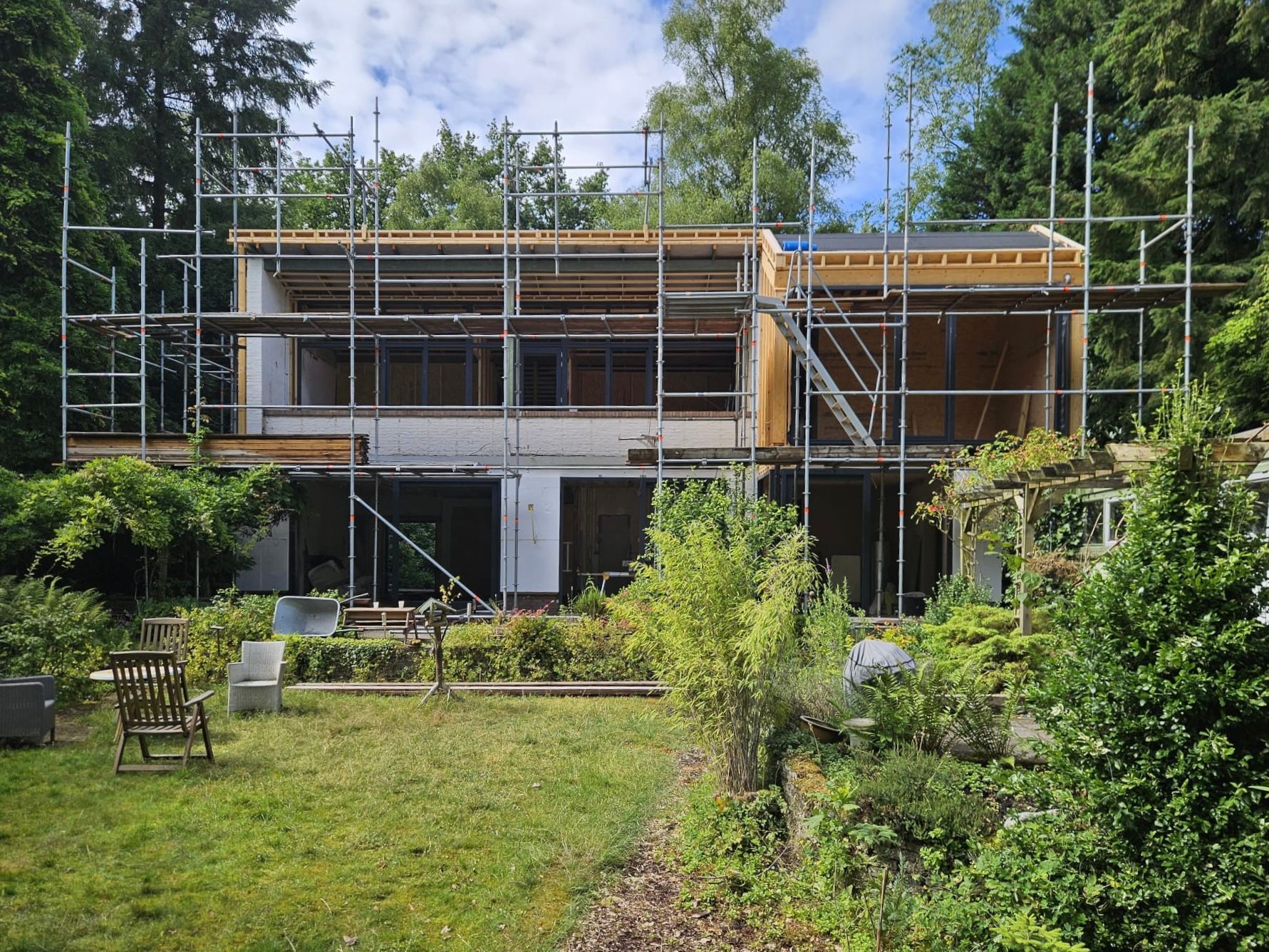 Bouwplaats steigers moderne woning verbouwing. Aannemer bouwfase constructie aanbouw.