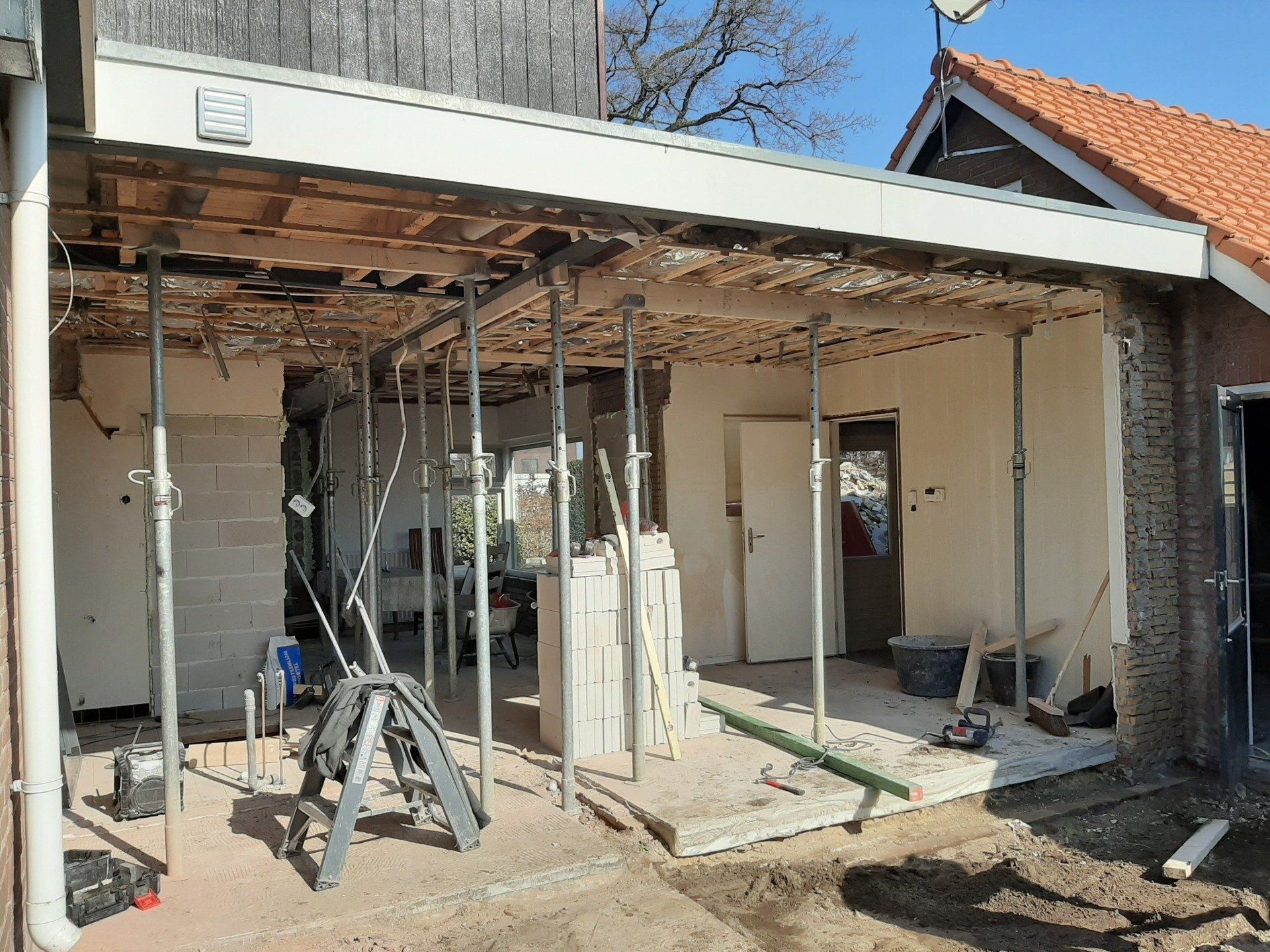 Aanbouw onder constructie met ramen en deuren. Woninguitbouw en aanbouwwerk.