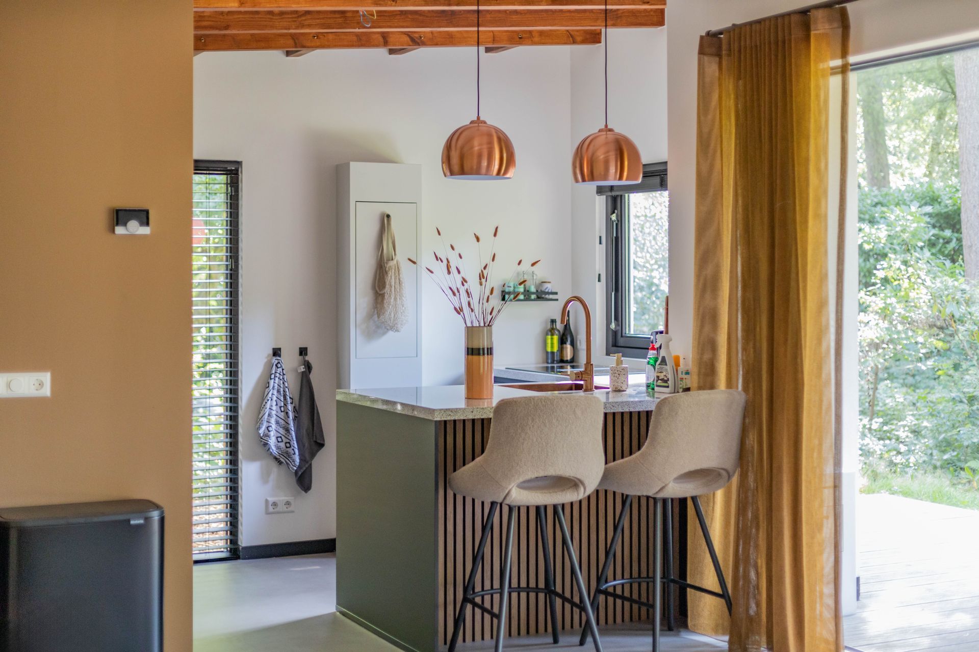 Gerenoveerde keuken en eetkamer met moderne afwerking en houten details.
