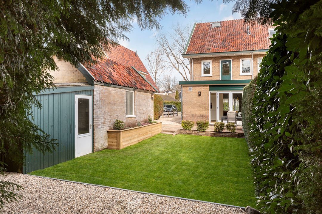 Moderne woning bakstenen aanbouw. Tuinaanbouw klein gebouwtje. Verbouwing renovatie.