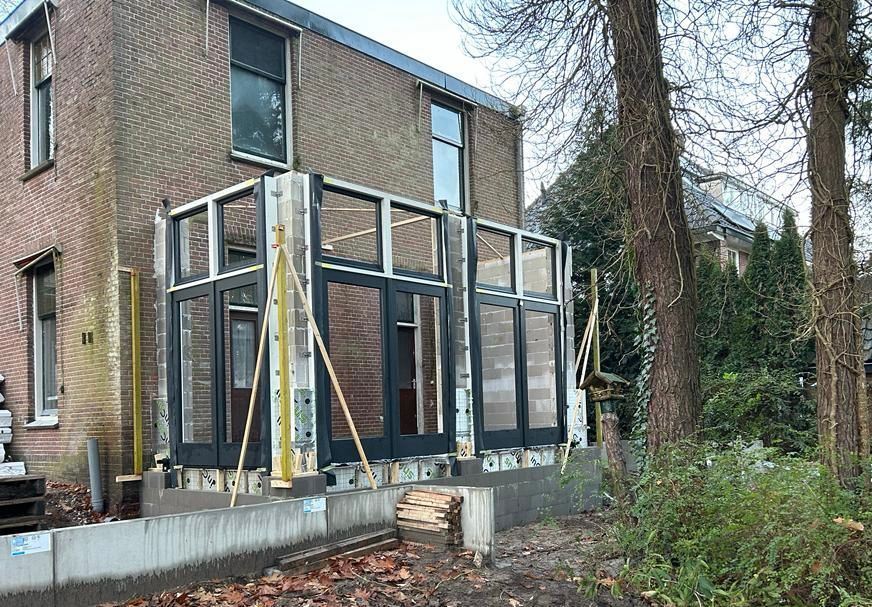 Grote glazen deuren en ramen tijdens aanbouw. Moderne uitbreiding woonhuis verbouwing.