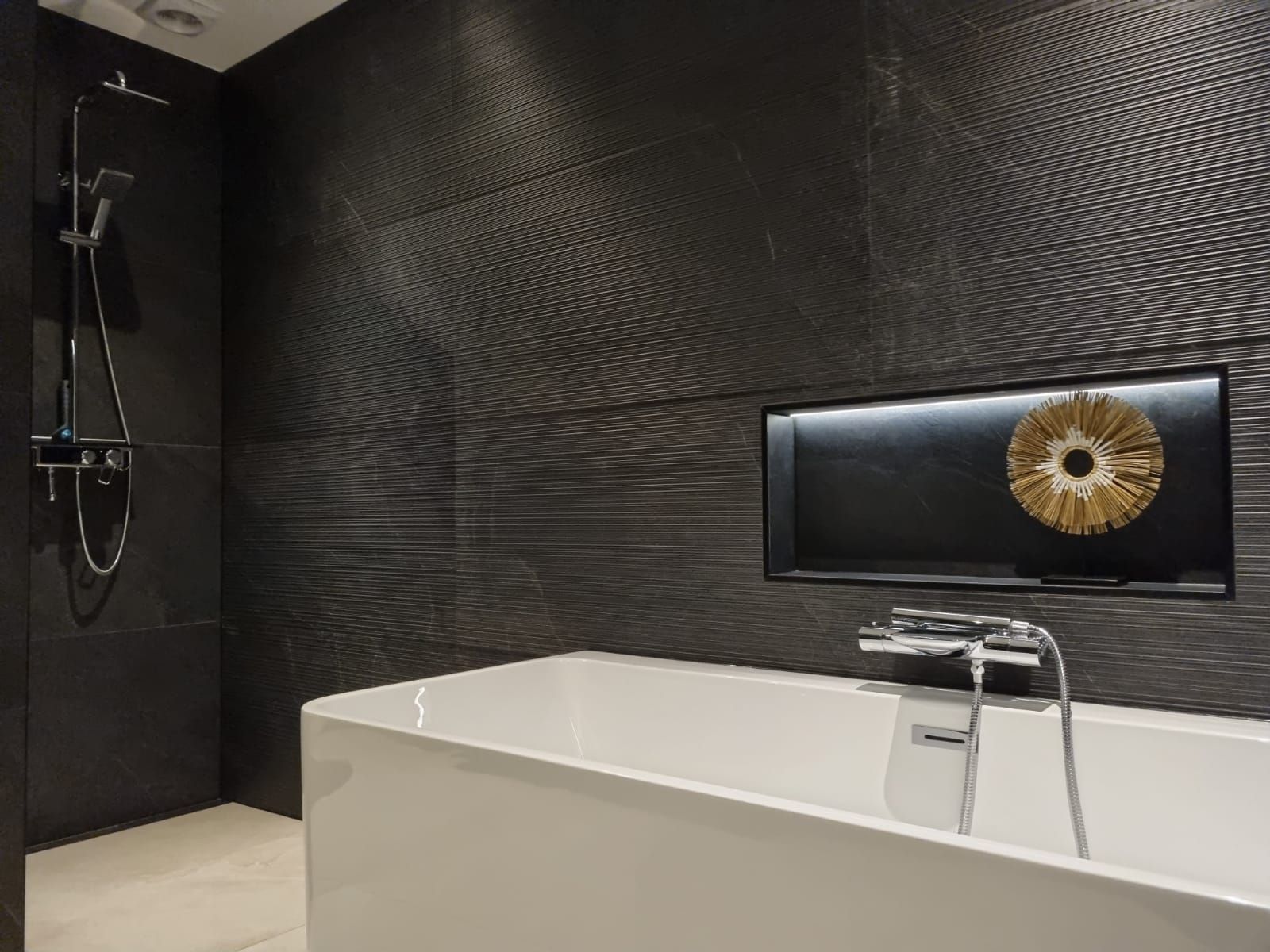 Moderne badkamer zwart tegels wit bad. Badkamerrenovatie luxe