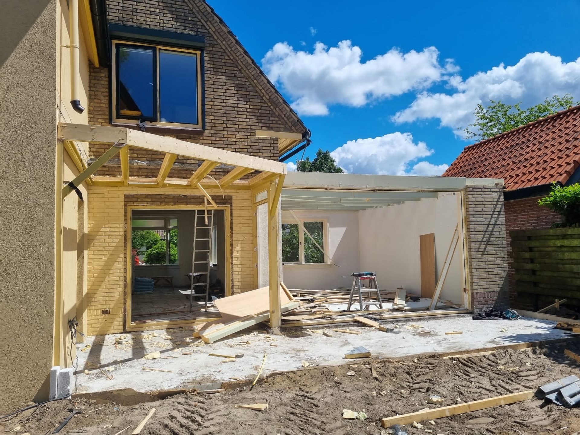 Aanbouw constructie. Houten frame pergola. Tuinaanbouw verbouwing woning.