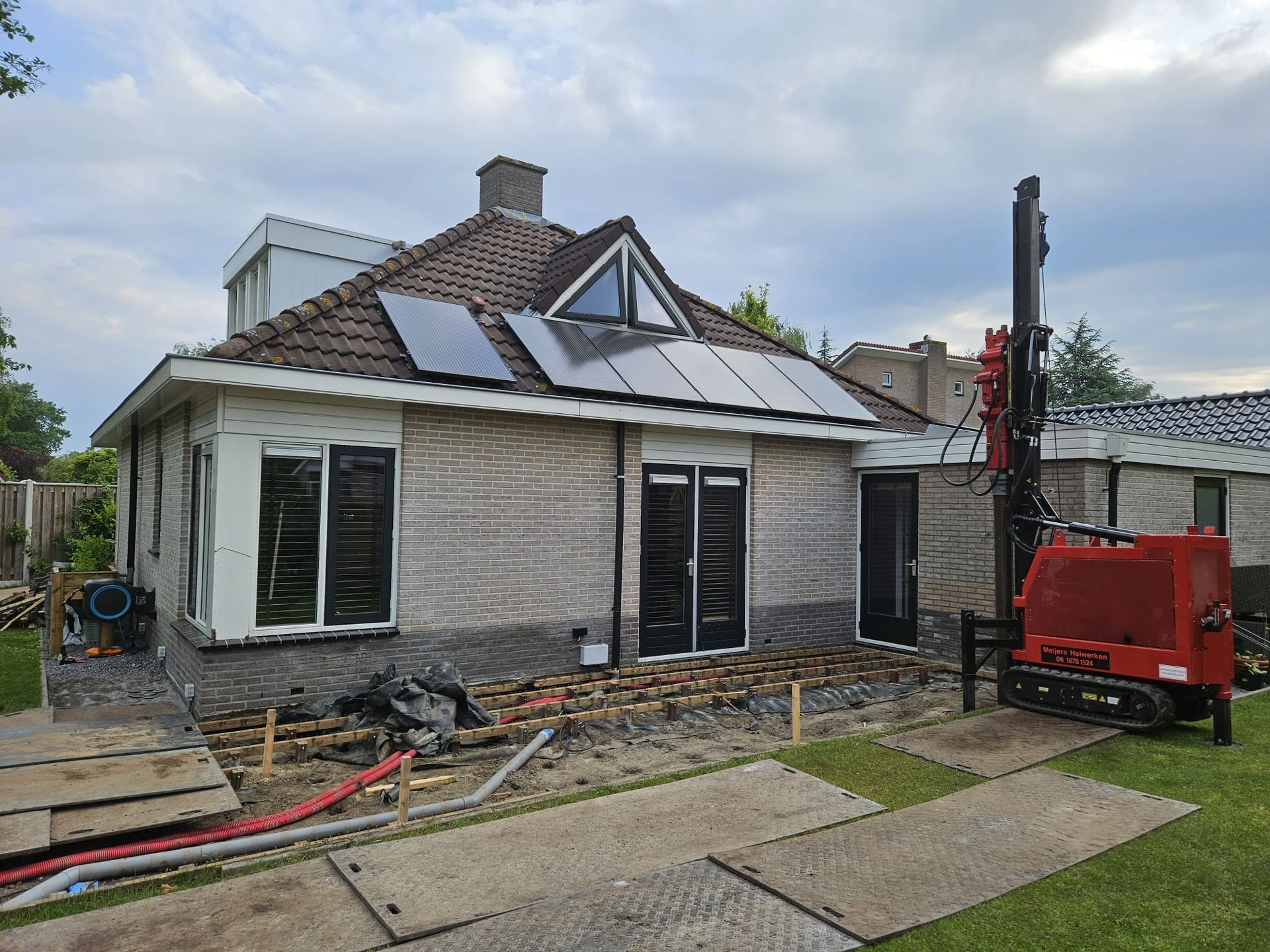 Woning met aanbouw en zonnepanelen tijdens verbouwing 