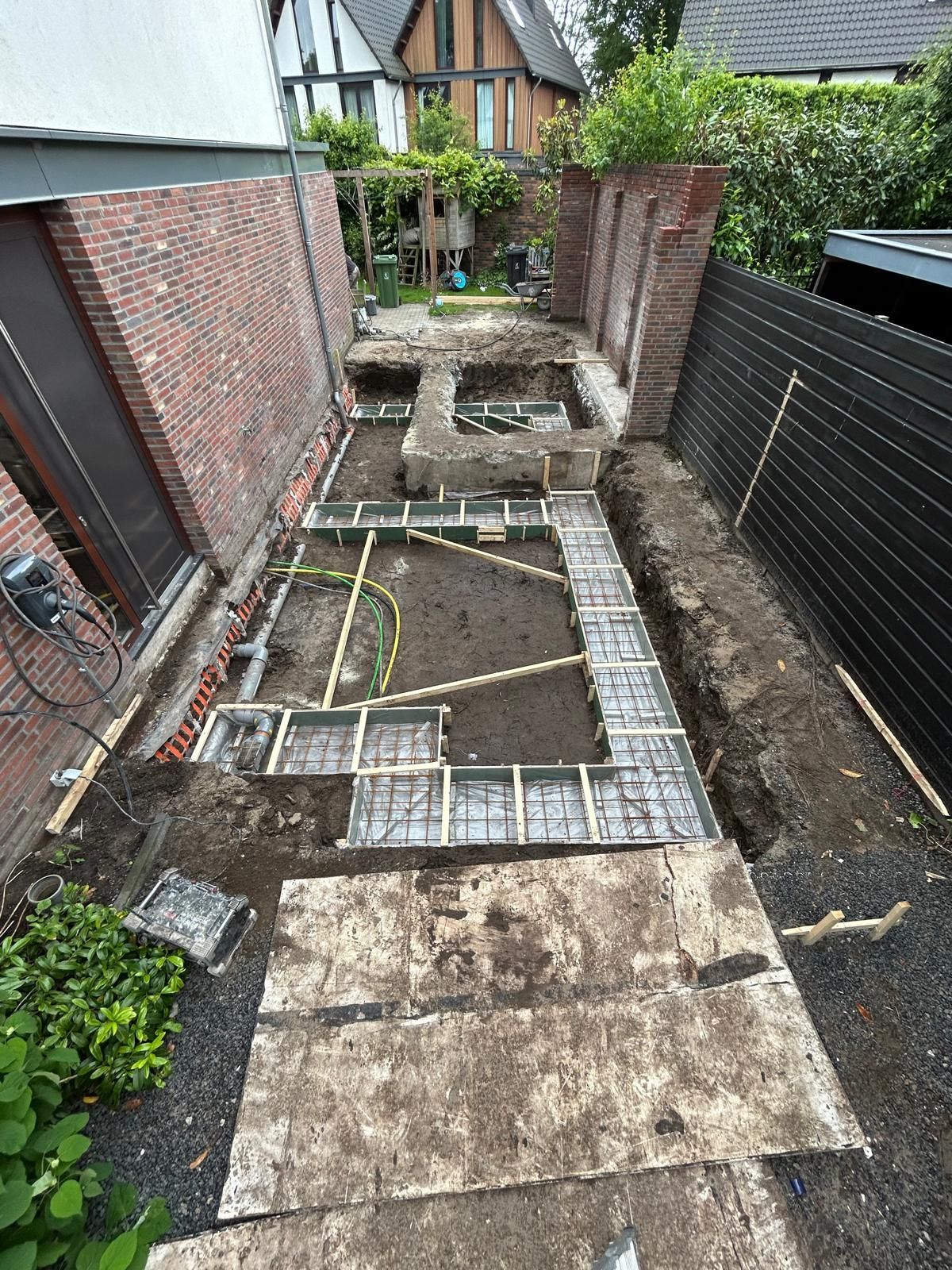 Smalle achtertuin in aanbouw met bakstenen muren