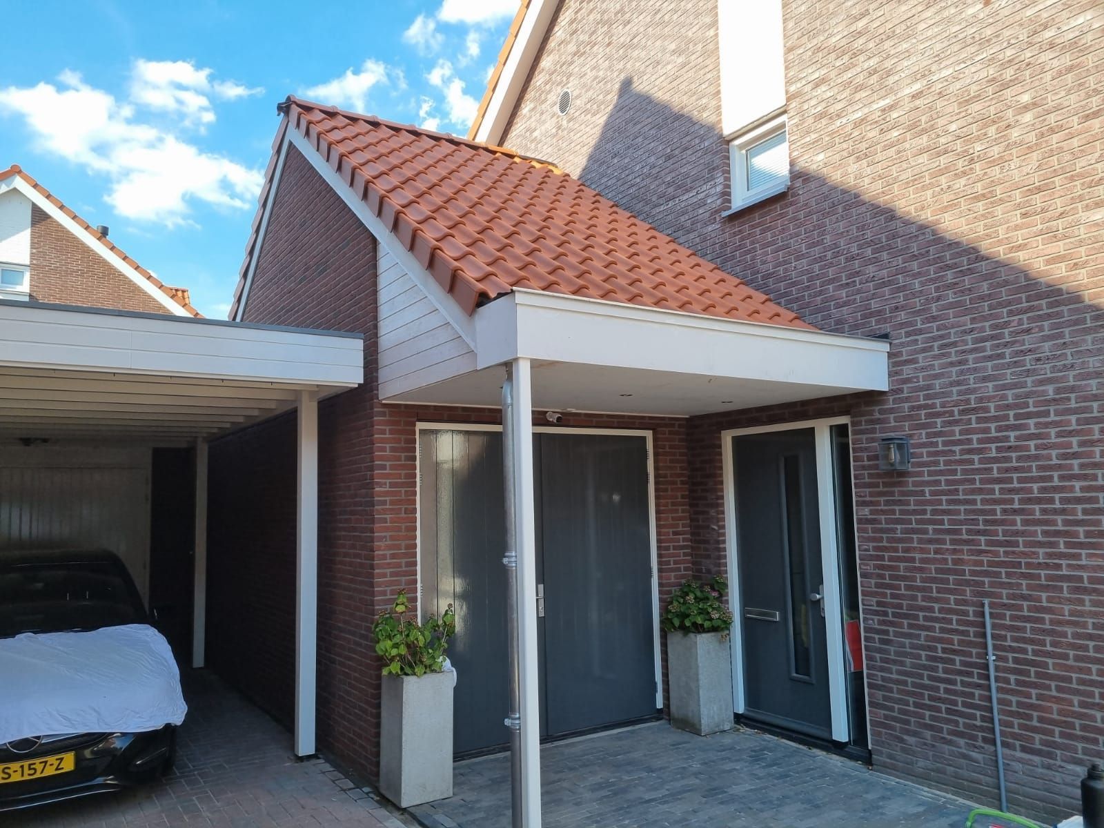 Huis dakpannen overstekking carport. Gerenoveerde woning aanbouw.