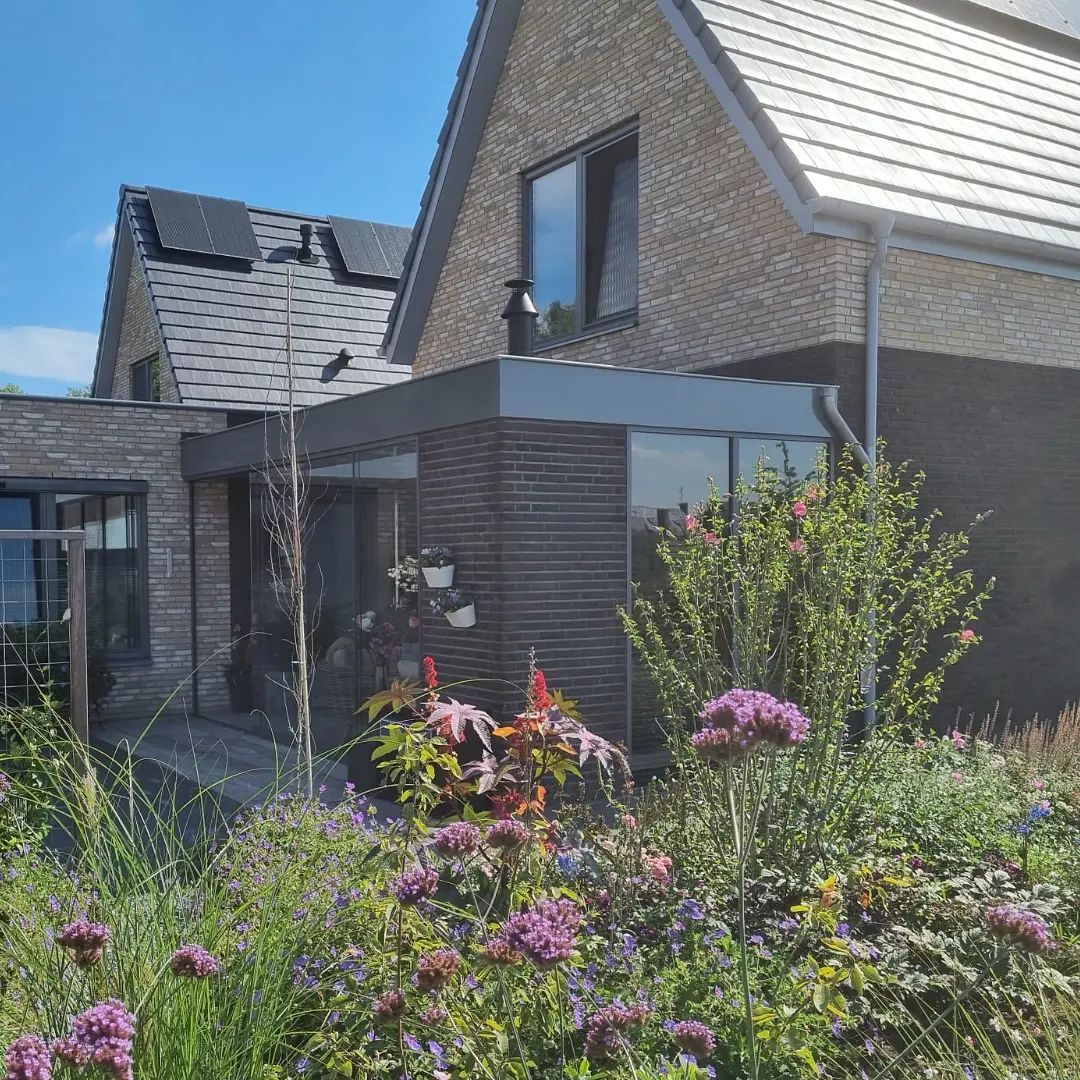 Moderne aanbouw architectuur. Donkere bekleding gevel renovatie.
