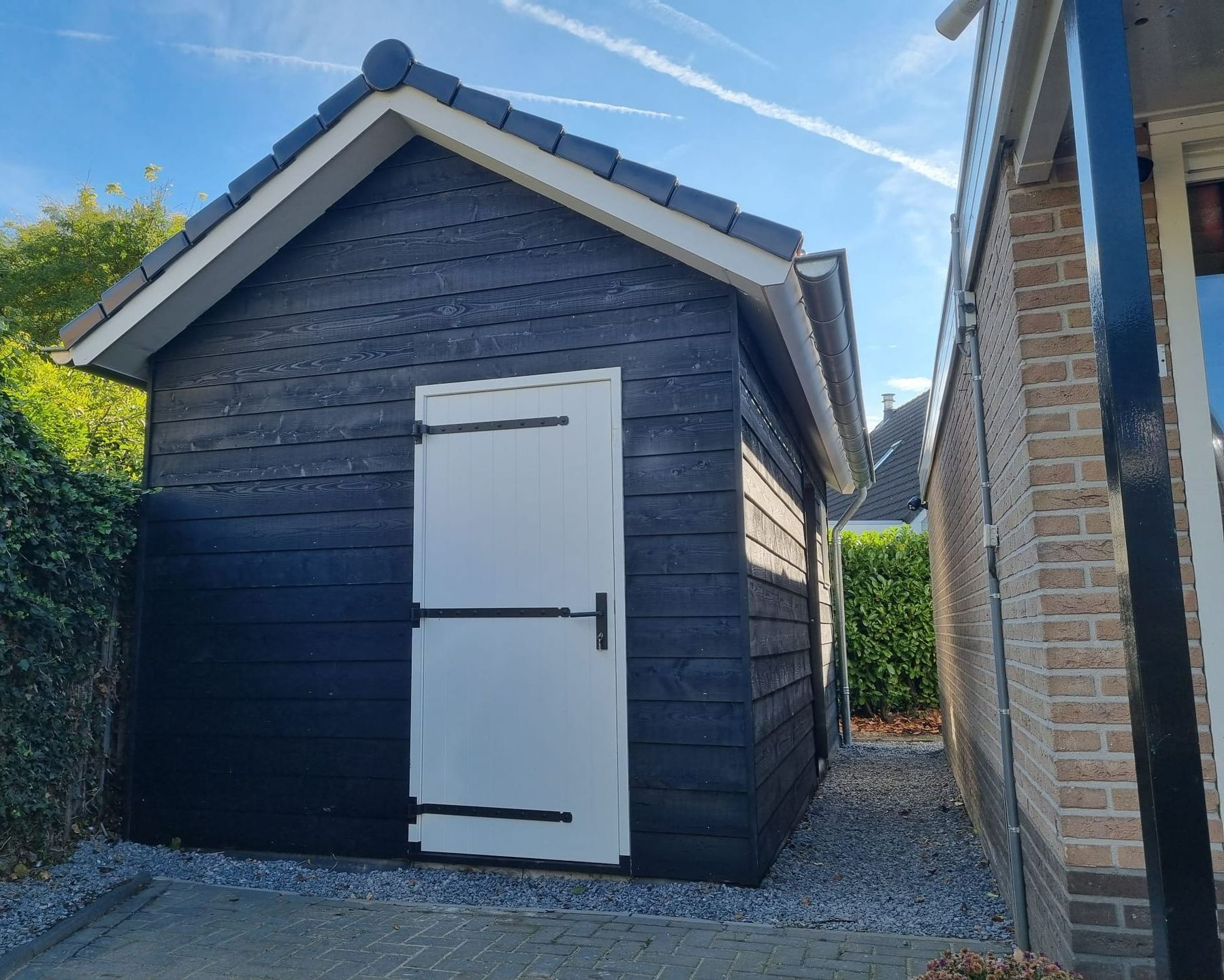 Tuinhuisverbouwing donkere gevel. Bijgebouw moderne daklijst