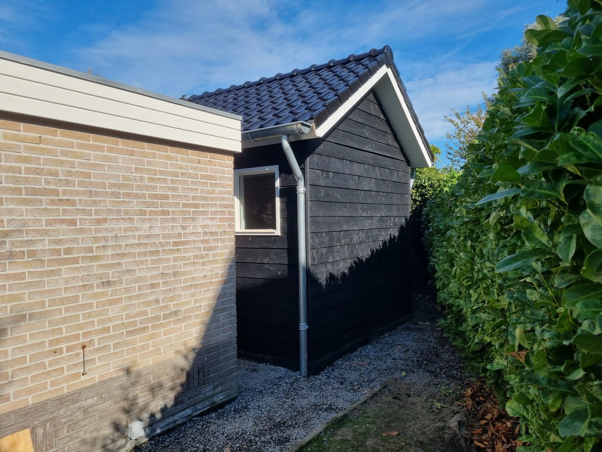 Tuinhuis bekleding. Grijze houten wanden met witte trim. Bouwwerk aanbouw.