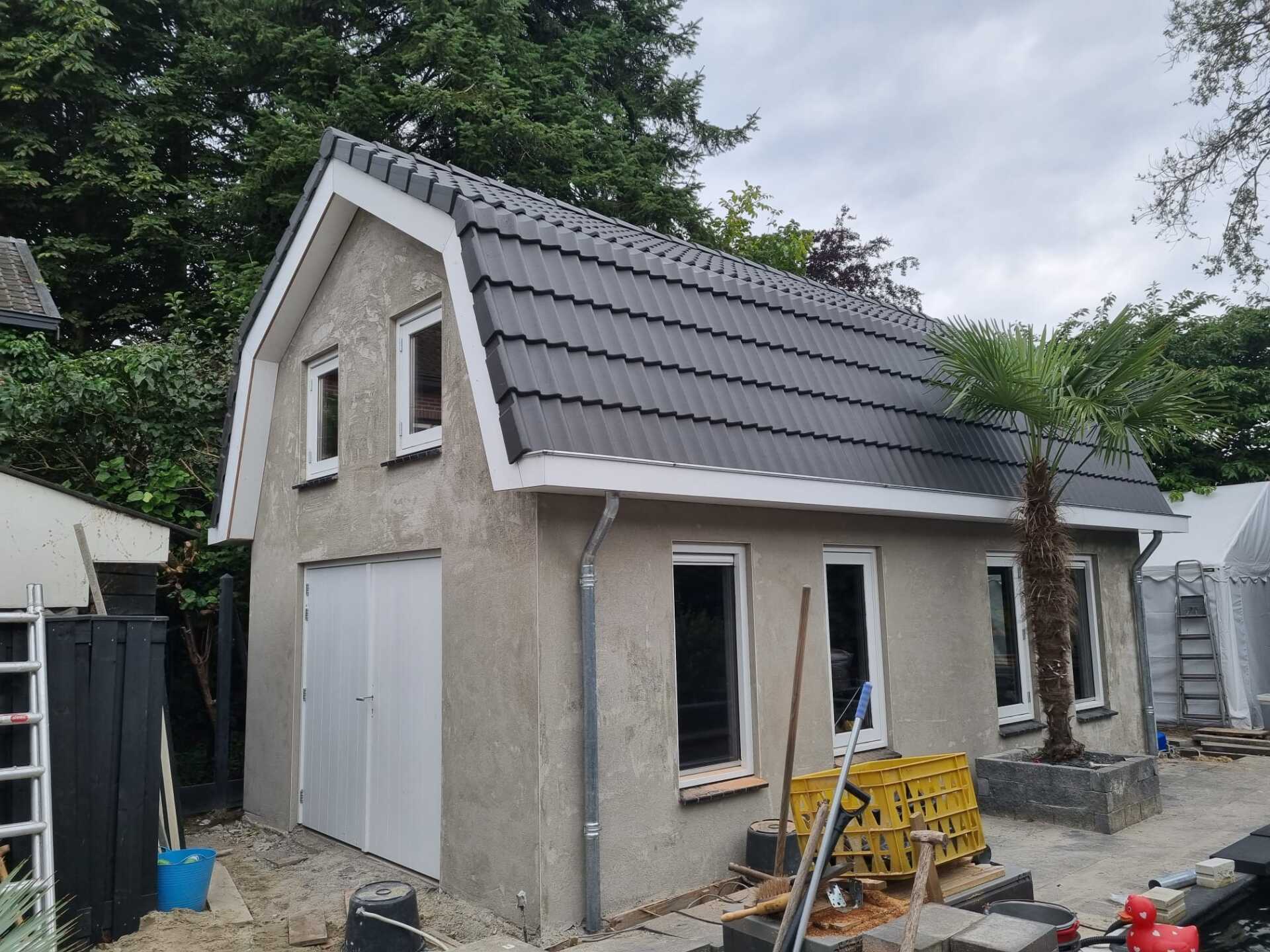 Nieuwbouw bijgebouw met grijs dak en garage