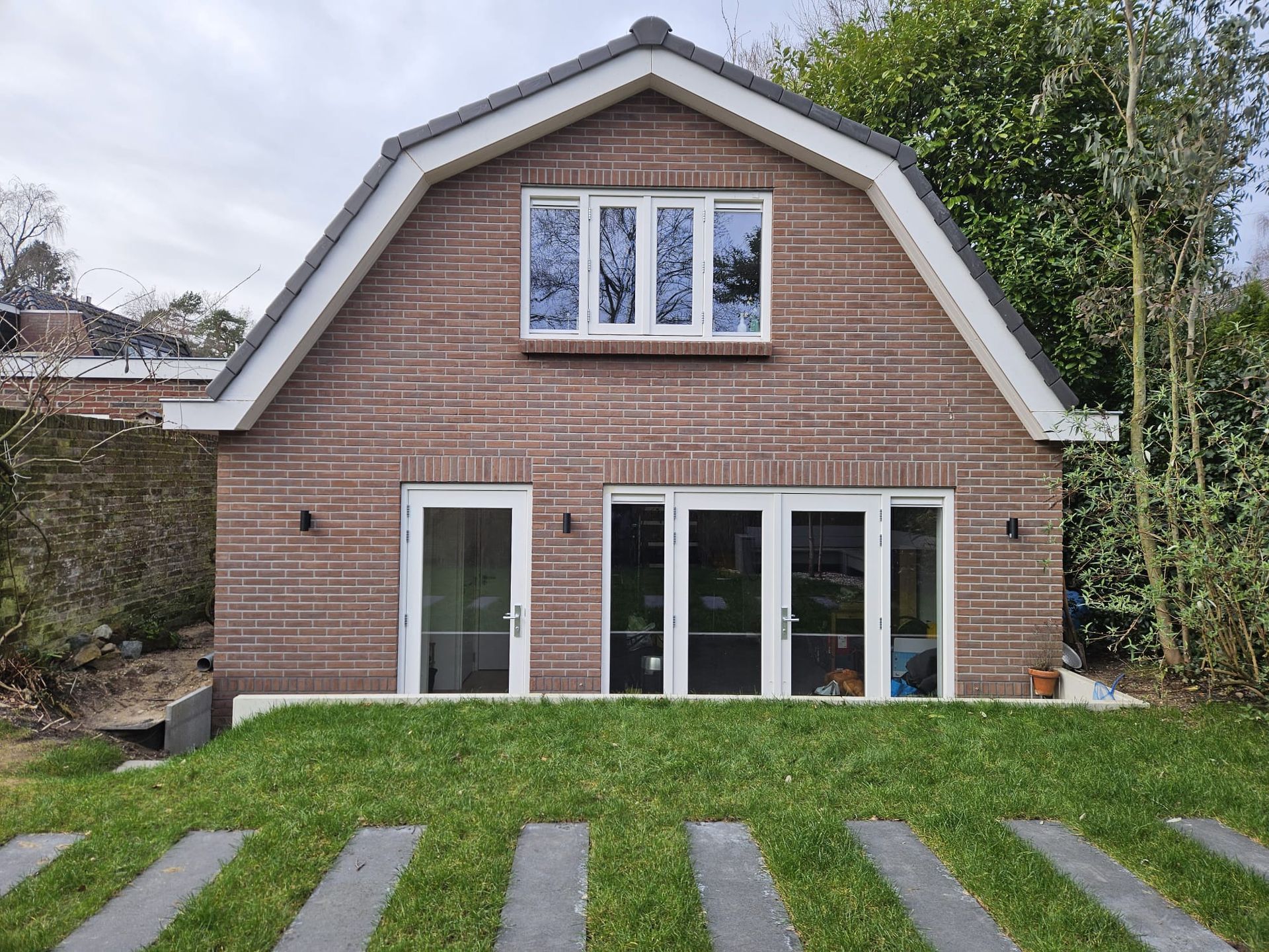 Gerenoveerde bakstenen woning met moderne ramen en deuren. aanbouw.