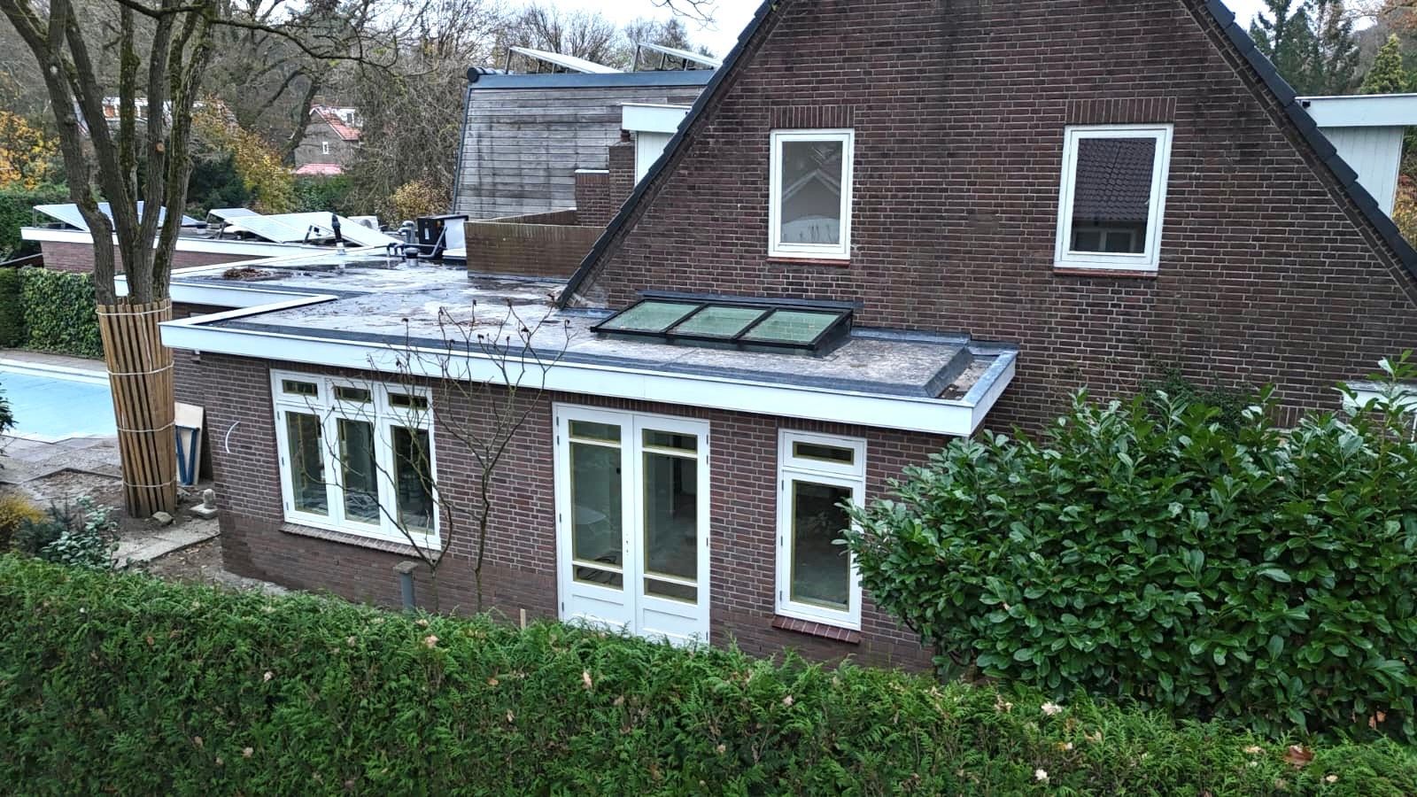 Bakstenen aanbouw moderne afwerking. Dakraam terras. Verbouwing interieur.