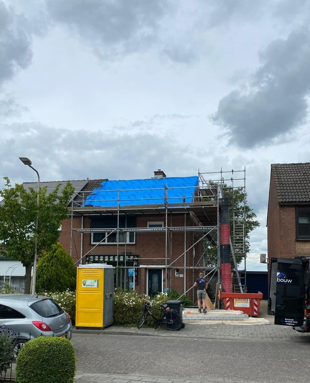 Dakwerk met blauwe bescherming in constructie. Dakverbouwing en renovatiewerkzaamheden.