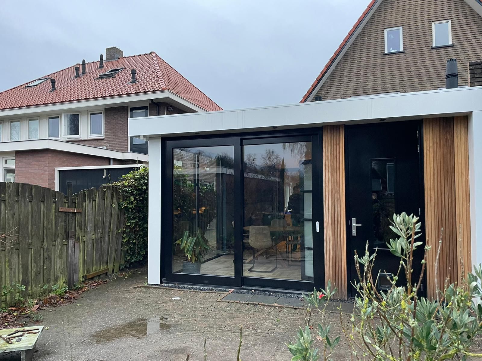 Aanbouw met houten gevel en grote ramen