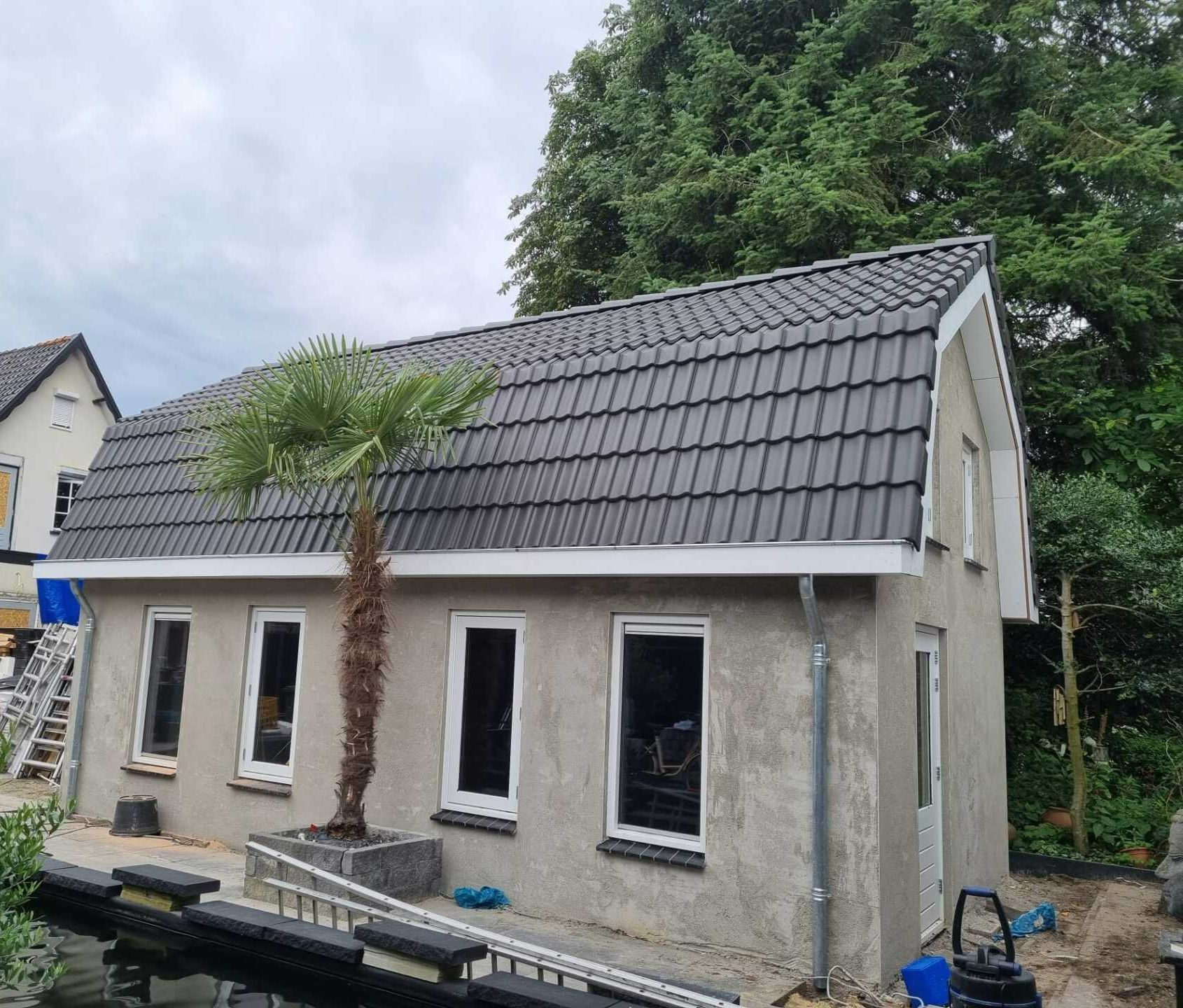 Nieuw dak met grijze dakpannen op bijgebouw