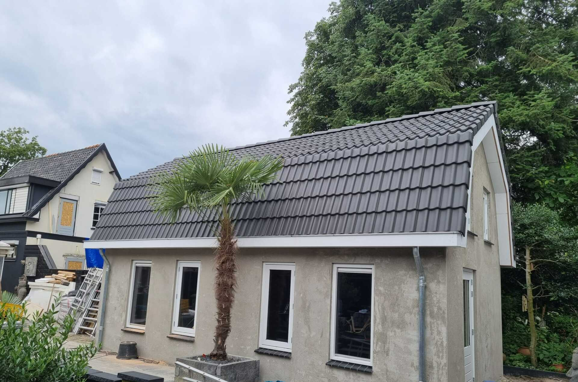 Woning tijdens dakrenovatie met nieuwe grijze dakpannen – verbouwing door aannemer