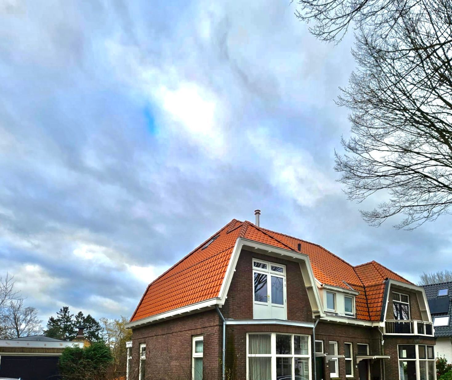 Rode dakpannen detail. Oranje dak renovatie op bakstenen huis.