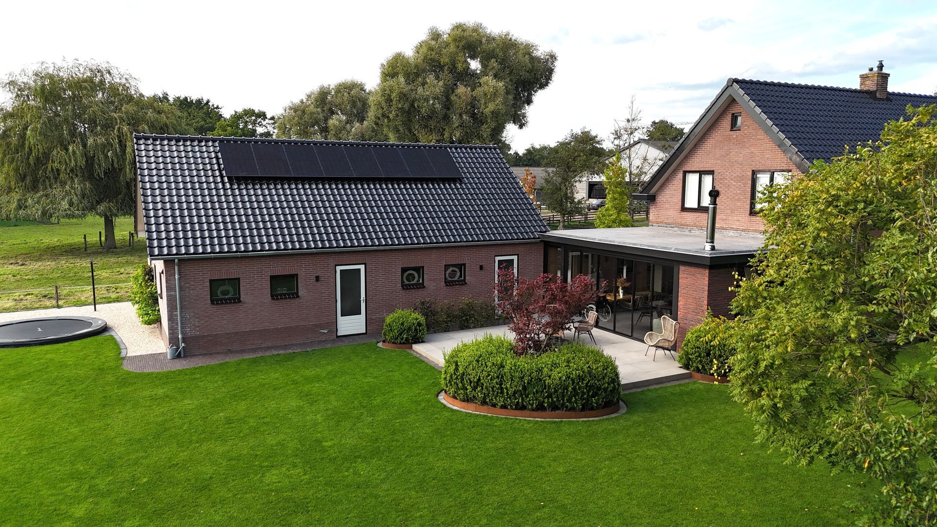 Gerenoveerde woning met moderne aanbouw en terras. Woninguitbouw en renovatie.