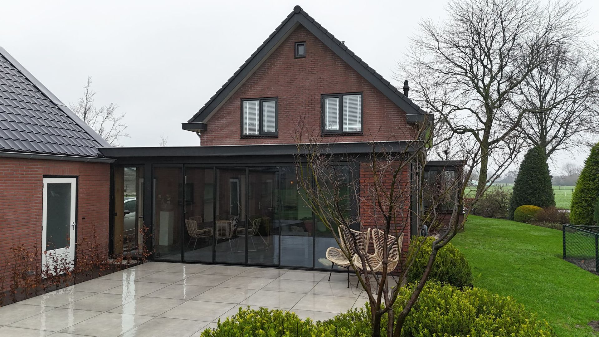 Gerenoveerde bakstenen woning met grote glazen aanbouw verbouwing.