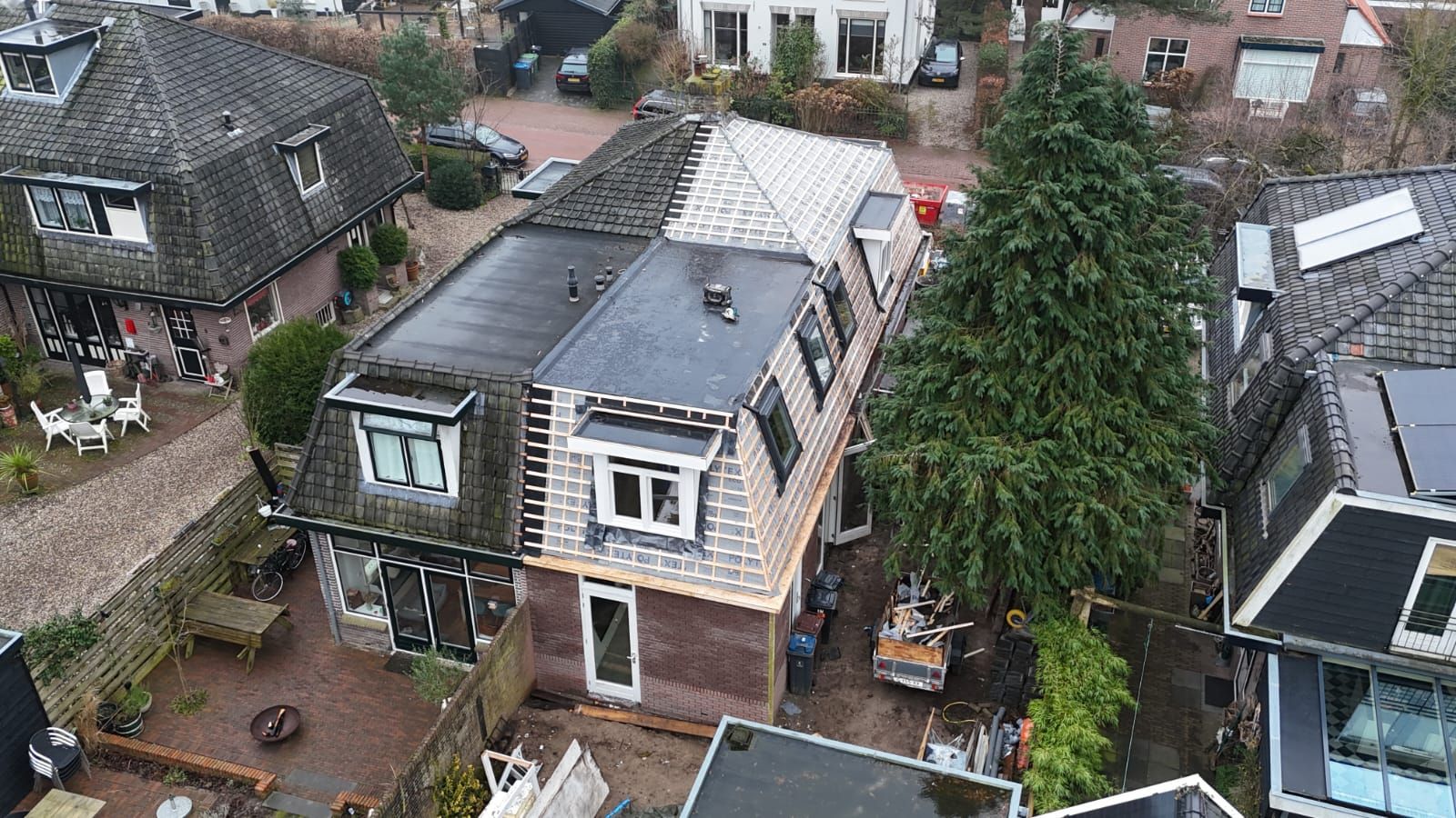 Dakrenovatie woning. Plat dak met dakbedekking en dakkapel. Verbouwing huis