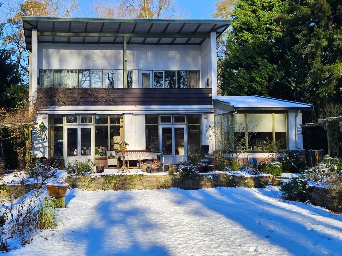 Huis donkere ramen grote glazen uitbouw. Aannemer verbouwing moderne woning.