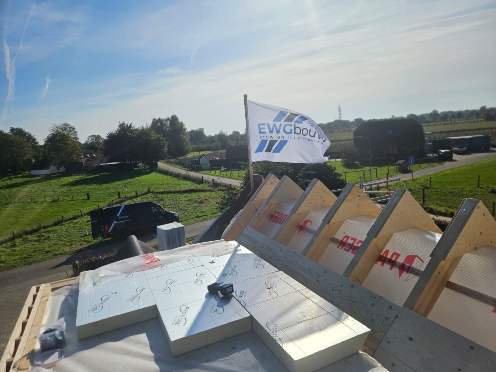 Bouwlocatie met materialen en EWG bouw banner. Woningverbouwing en bouwmaterialen.