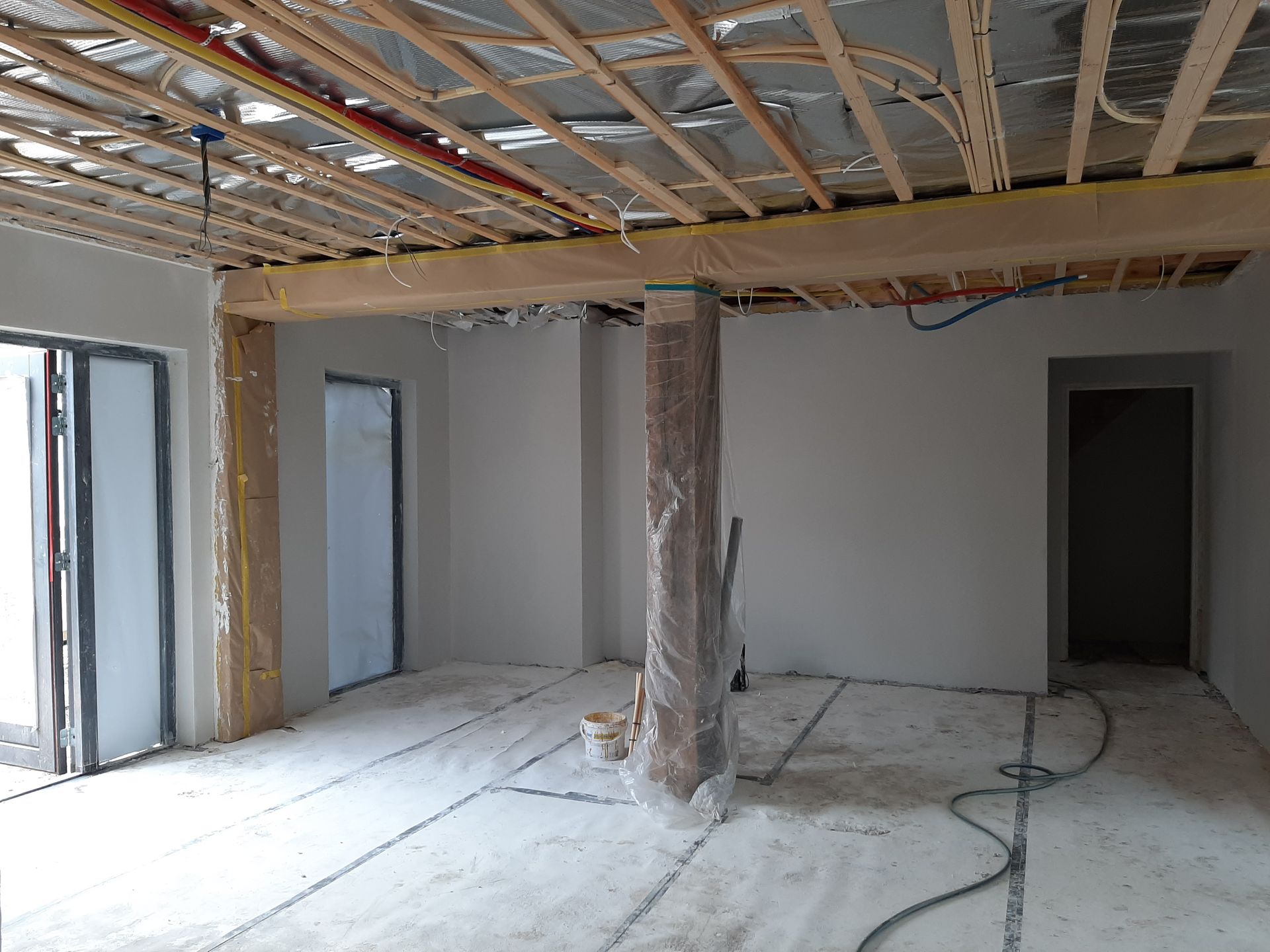Woonruimte tijdens verbouwing met nieuwe leidingen en dakconstructie