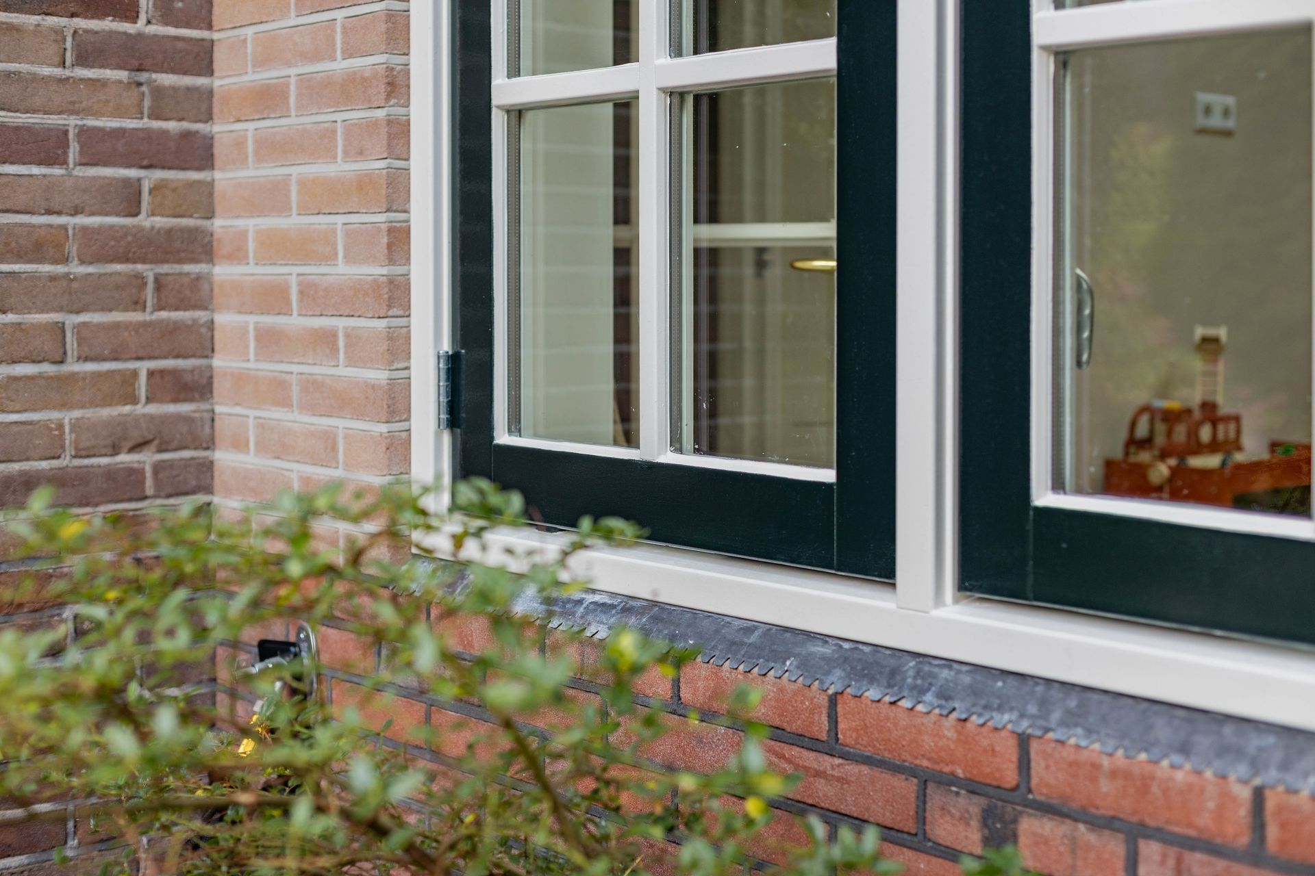 Zwart raam in bakstenen gevel. Moderne raamwerk plaatsen bij renovatie woning.