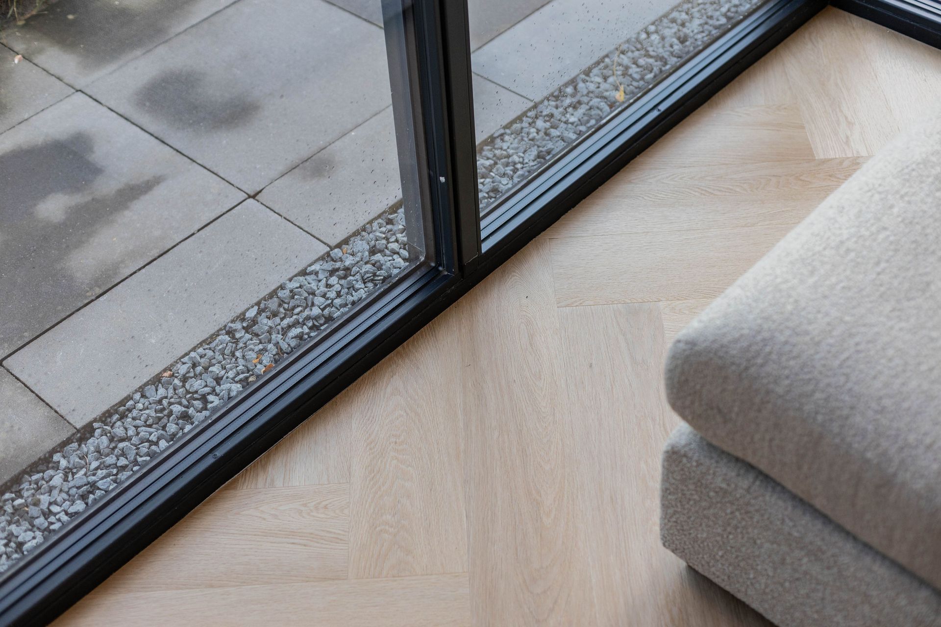 Interieur renovatie. Detail grijze vloer en donkere ramen.