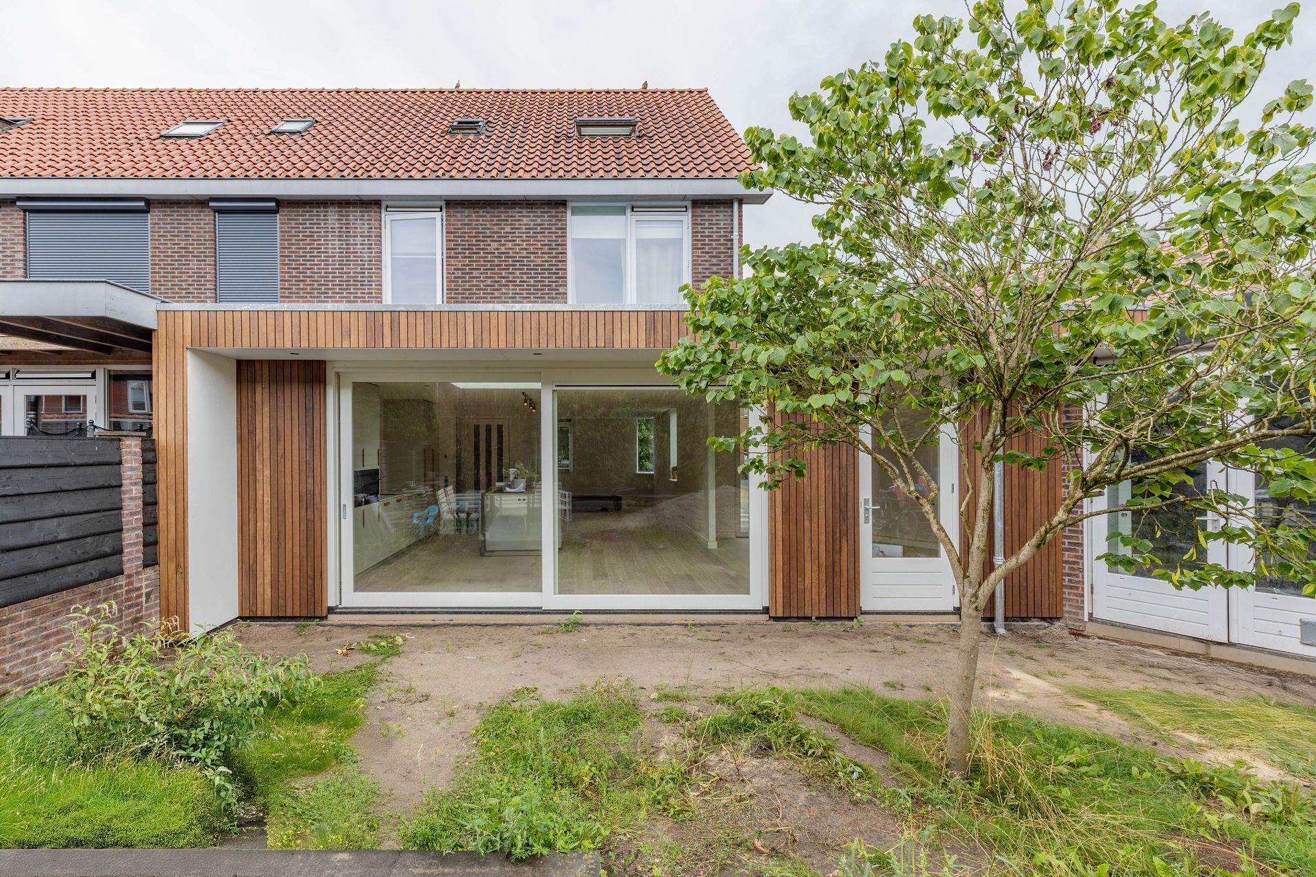 Grote glazen aanbouw houten bekleding. Terras uitbouw verbouwing.