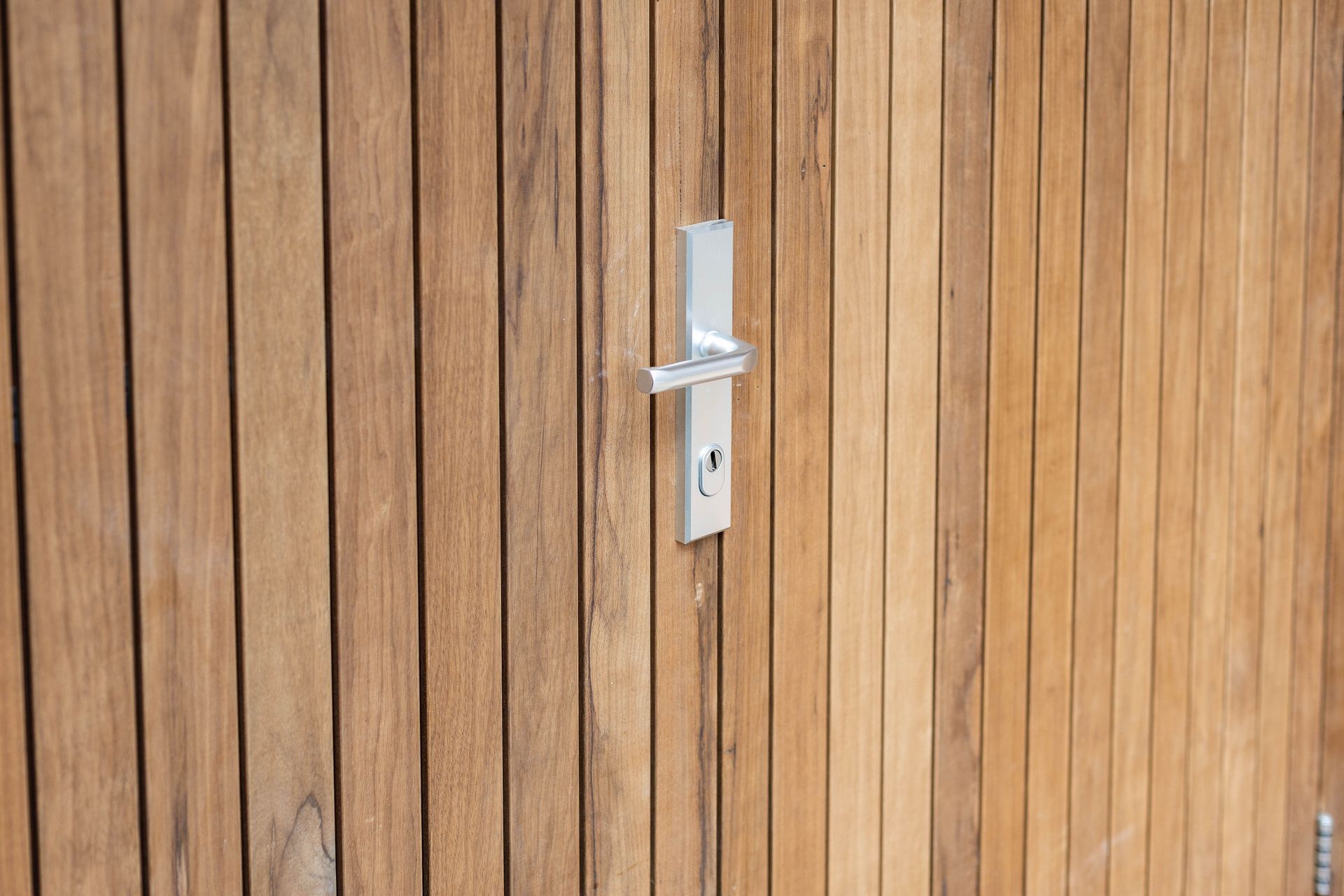 Houten deur verticaal patroon. Deurkruk hardware afwerking.