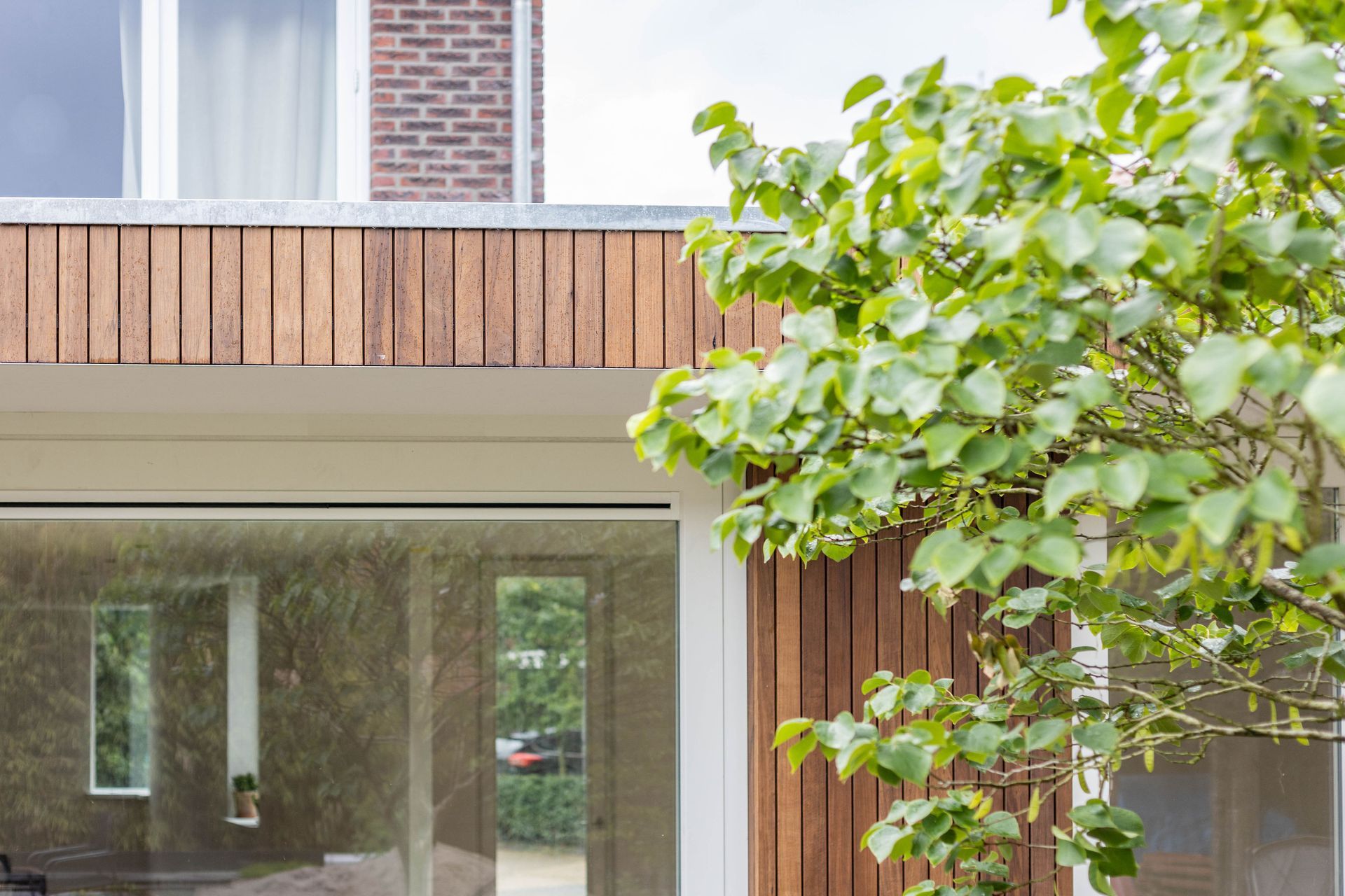 Houten beklading balkon. Glas raam trim afwerking. Aanbouw renovatie.