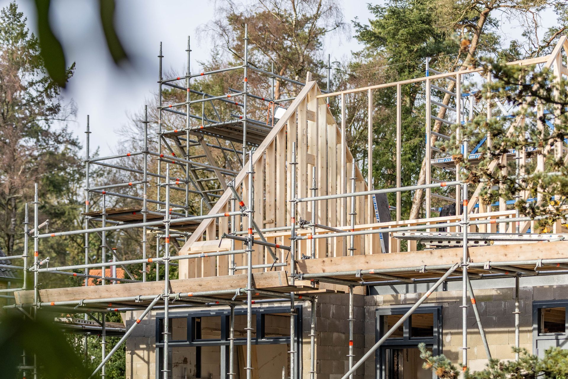 Aanbouw constructie met stellingen. Houten skelet bouwproces. Verbouwing renovatie.