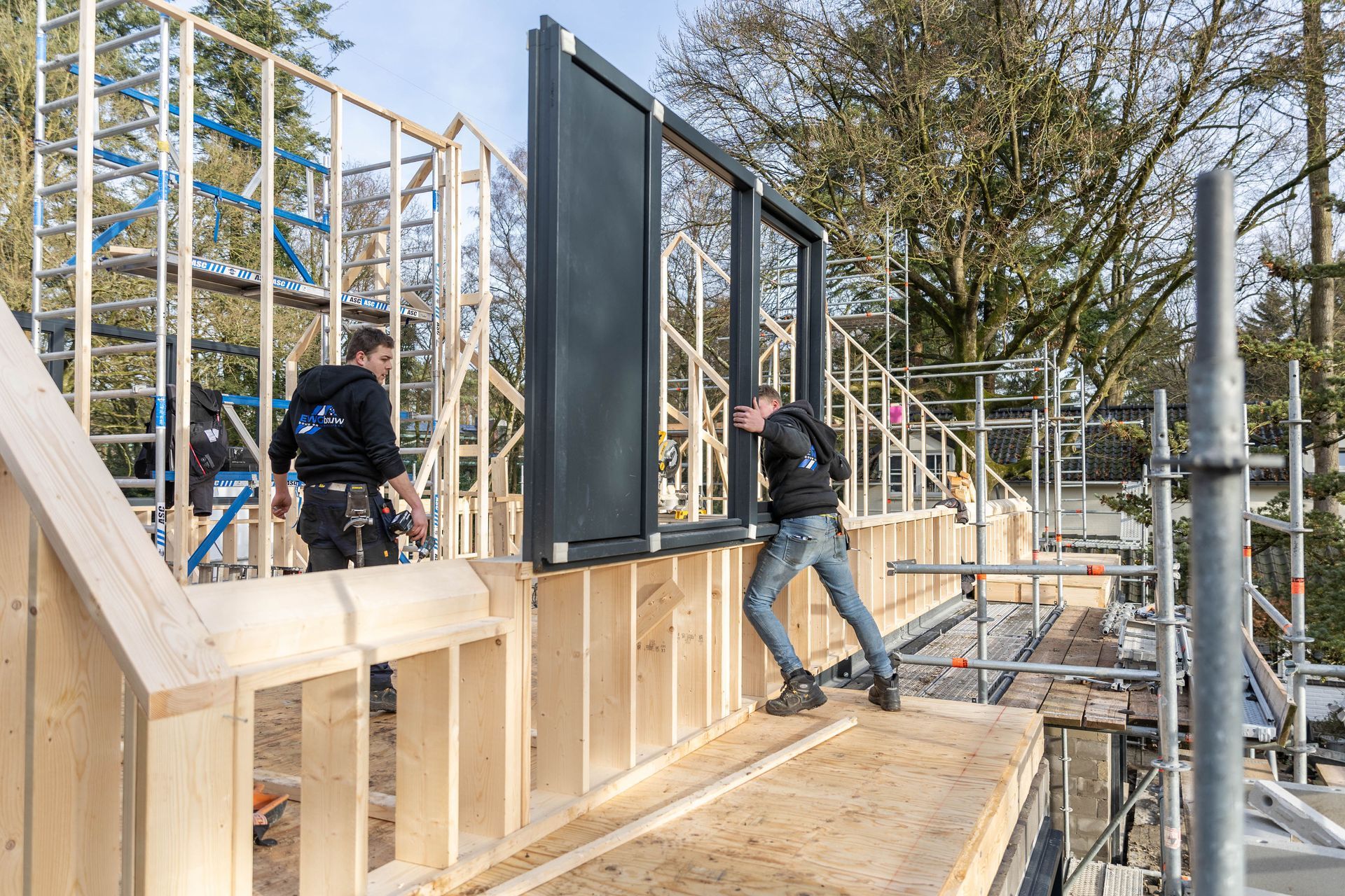 Aanbouw constructie houten wand. Skelet bouwproces zwarte bekleding. Verbouwing.