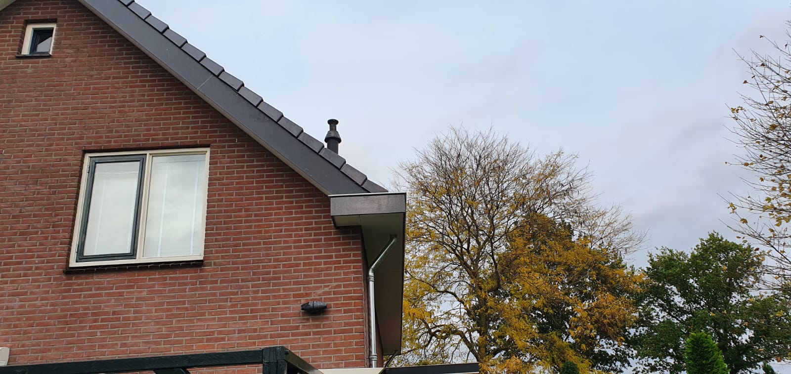Dakafwerking aan bakstenen woning. Renovatie dak.
